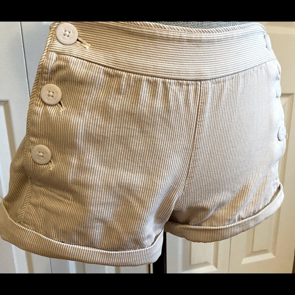 Beige pinstriped shorts with double button navy style front opening.